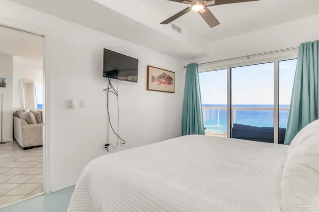 a bedroom with a balcony a bed and a flat screen tv