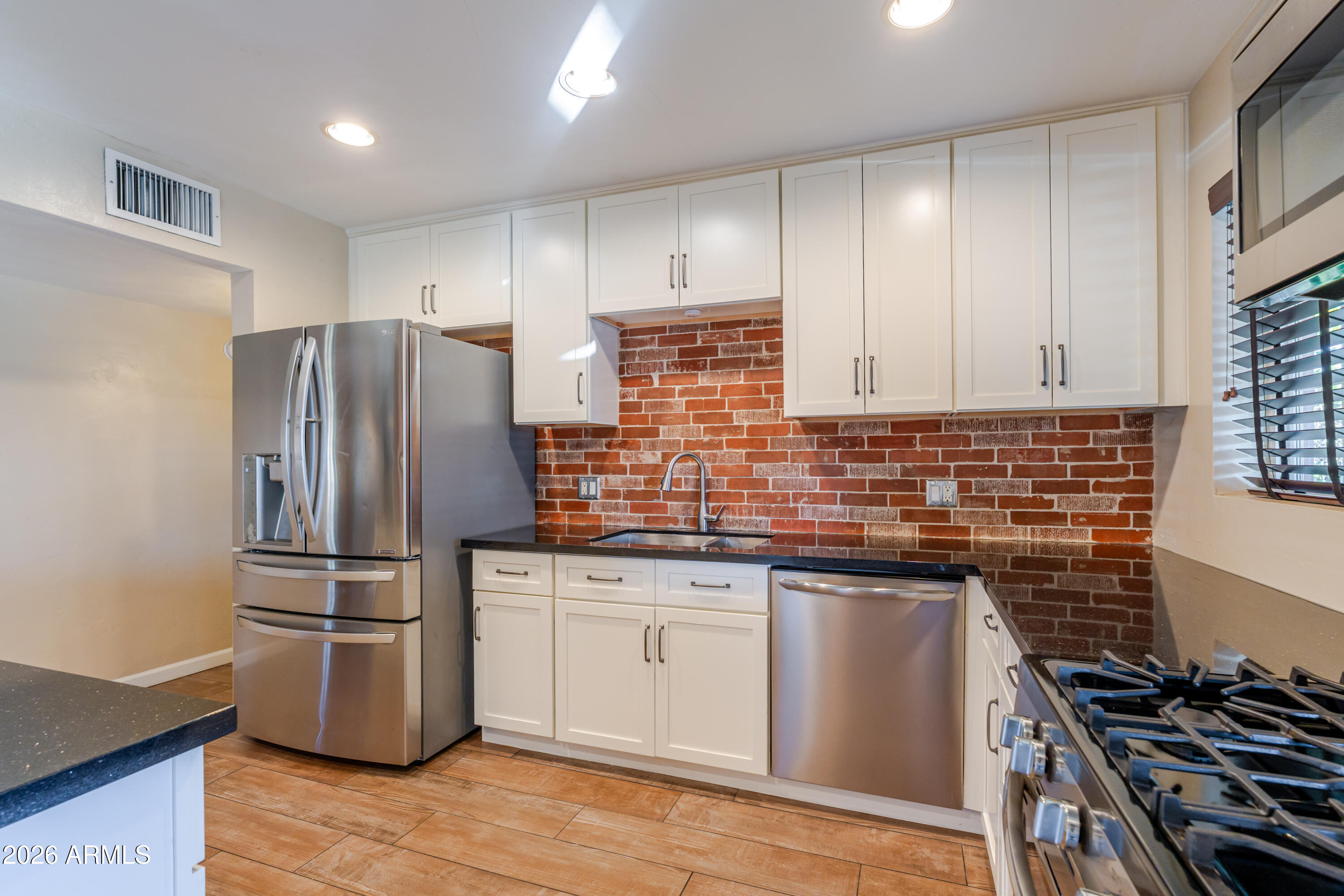 1631 West Rovey Avenue Phoenix, AZ 85015 - Photo 15 of 46 a kitchen with granite countertop stainless steel appliances and wooden cabinets