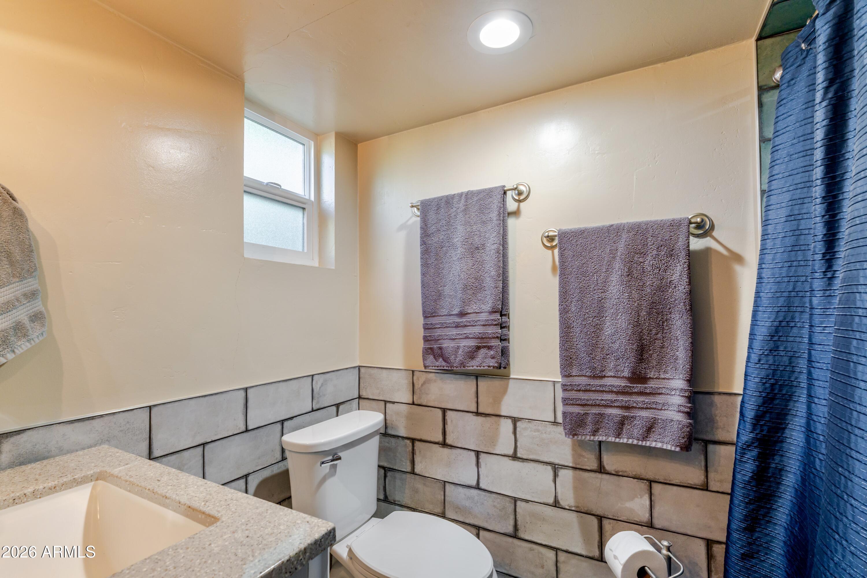 1631 West Rovey Avenue Phoenix, AZ 85015 - Photo 23 of 46 a bathroom with a toilet a sink and mirror