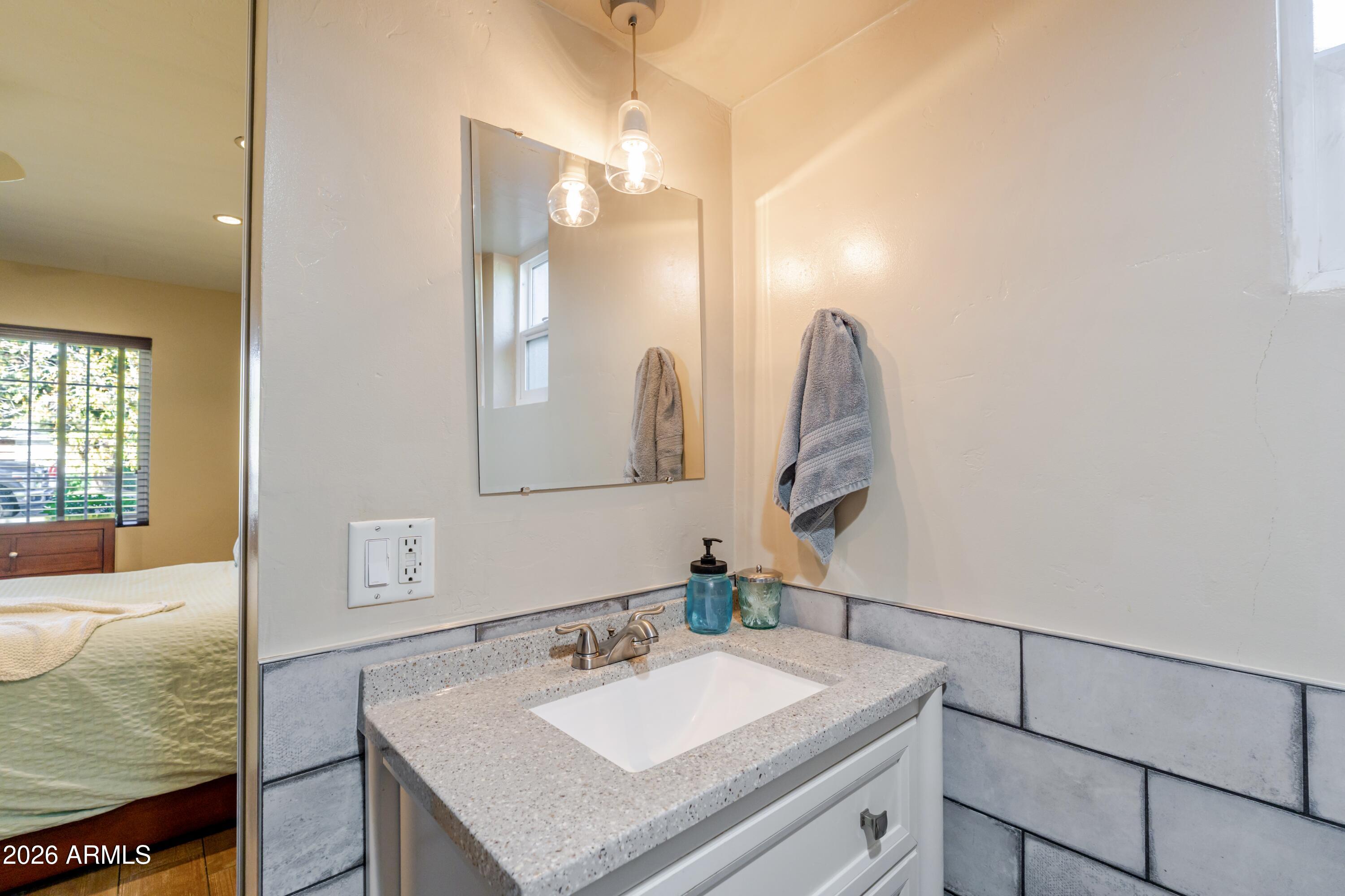 1631 West Rovey Avenue Phoenix, AZ 85015 - Photo 24 of 46 a bathroom with a sink vanity and a mirror