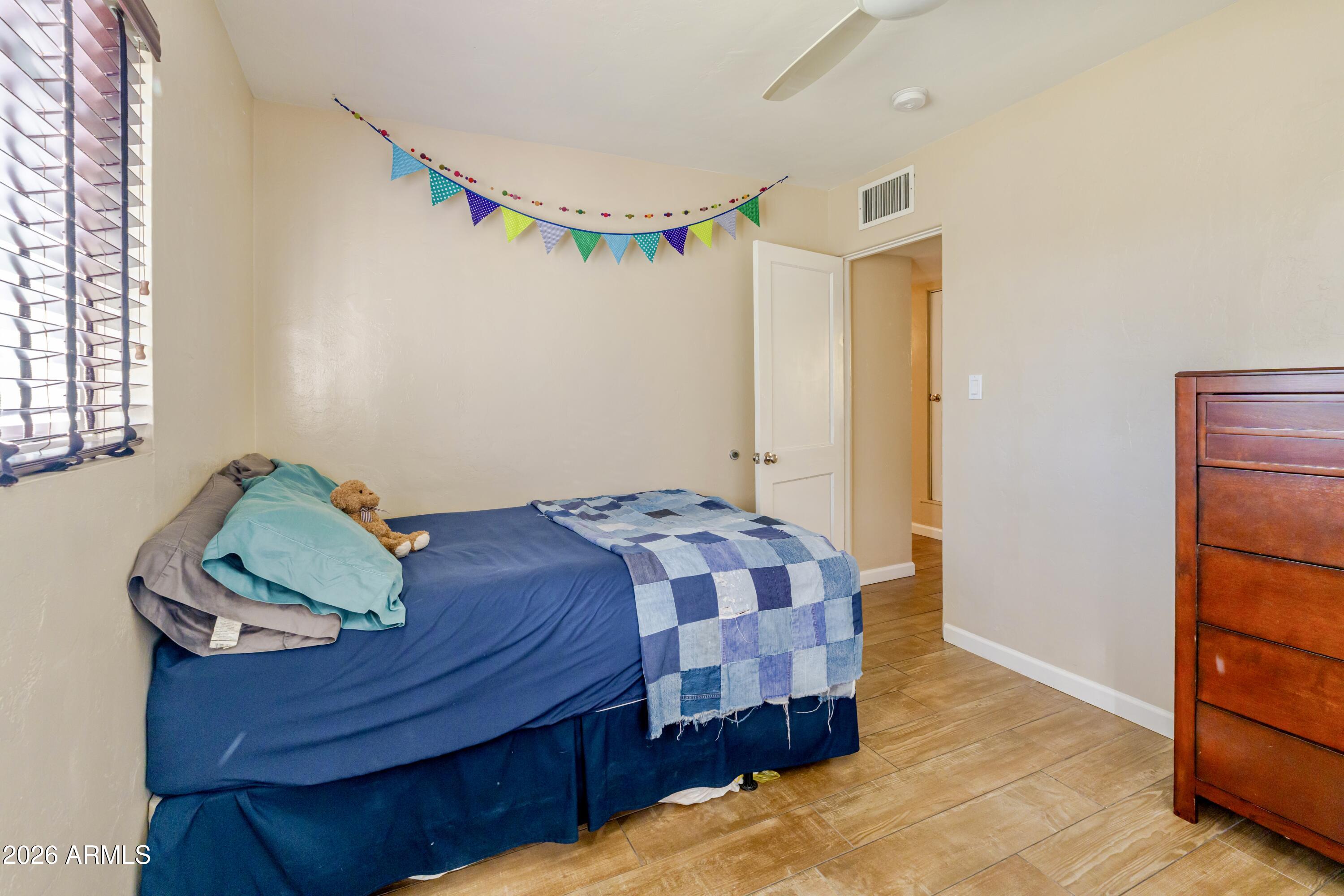 1631 West Rovey Avenue Phoenix, AZ 85015 - Photo 28 of 46 a bedroom with a bed and a window