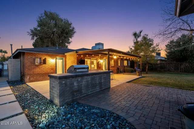 a view of a house with backyard and sitting area