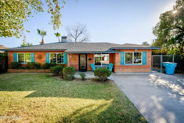 a front view of a house with a yard and potted plants