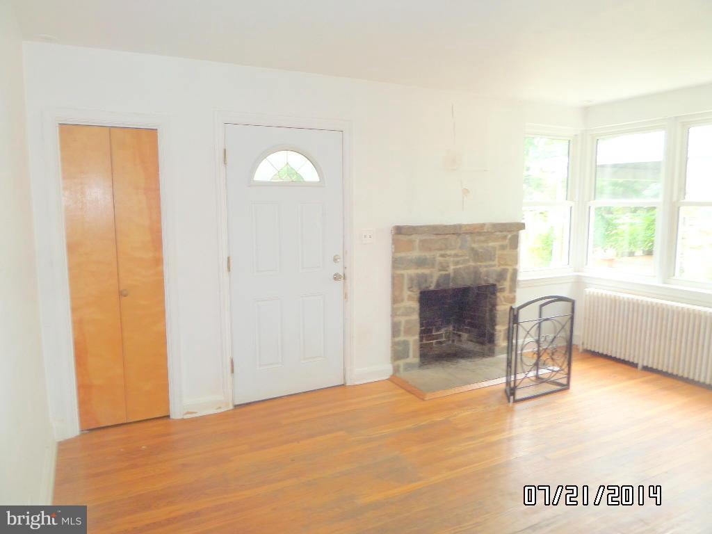 608 Cliveden Road Baltimore, MD 21208 - Photo 2 of 23 a view of an empty room with a fireplace and a window
