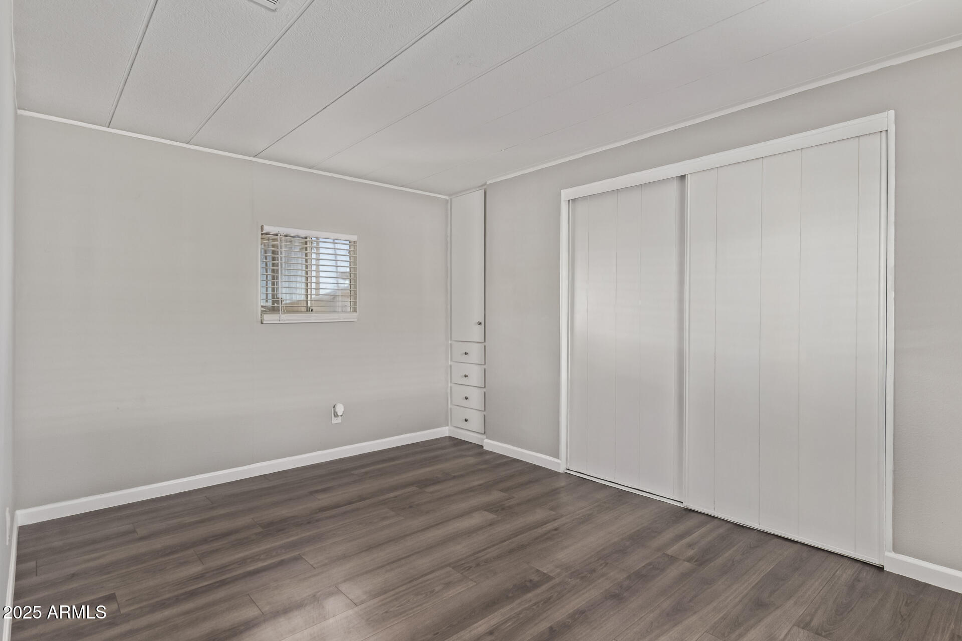 303 South Recker Road, Unit 200 Mesa, AZ 85206 - Photo 17 of 29 a view of an empty room with wooden floor and a window