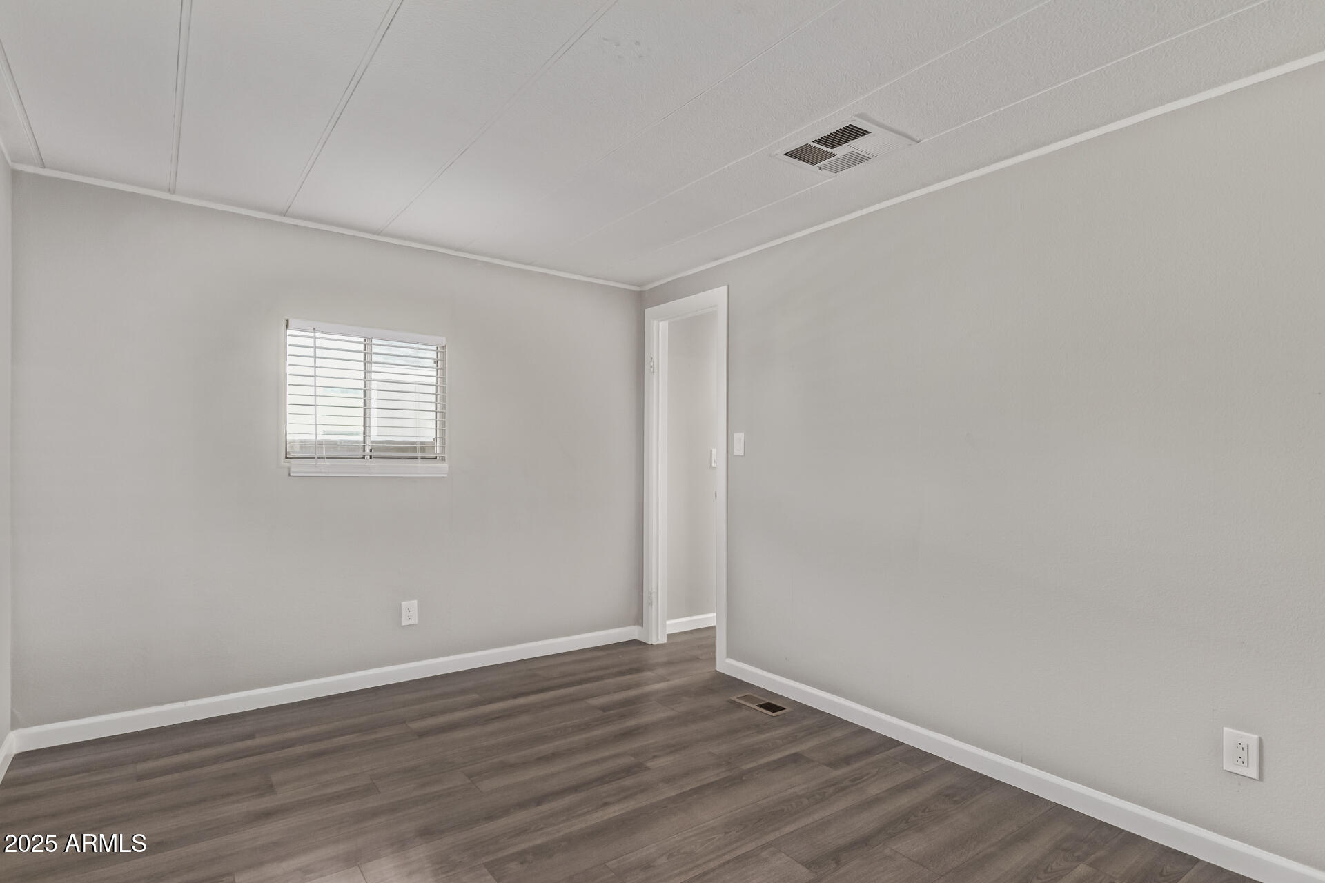 303 South Recker Road, Unit 200 Mesa, AZ 85206 - Photo 19 of 29 a view of an empty room with wooden floor and a window
