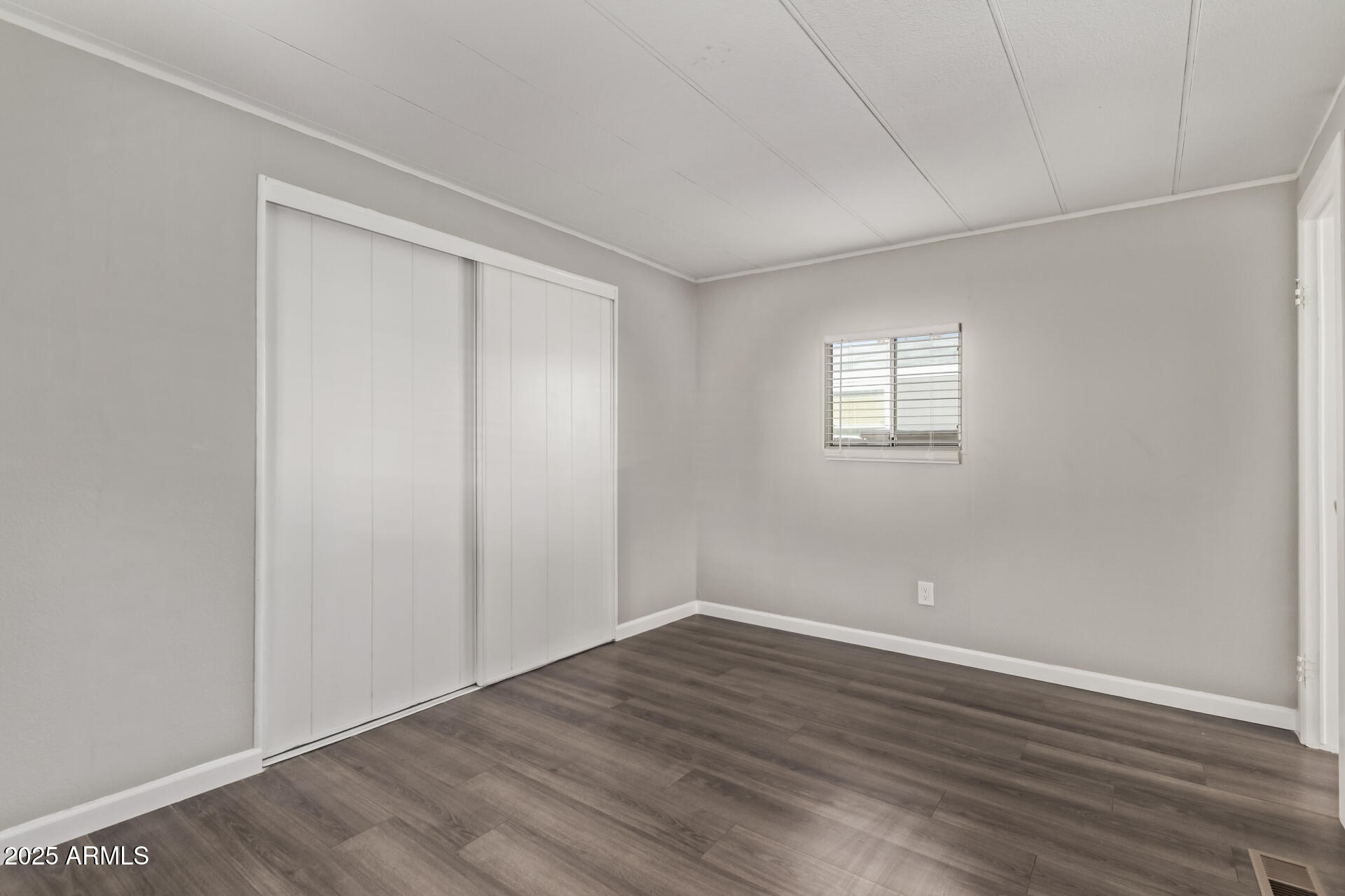 303 South Recker Road, Unit 200 Mesa, AZ 85206 - Photo 20 of 29 a view of an empty room with wooden floor and a window