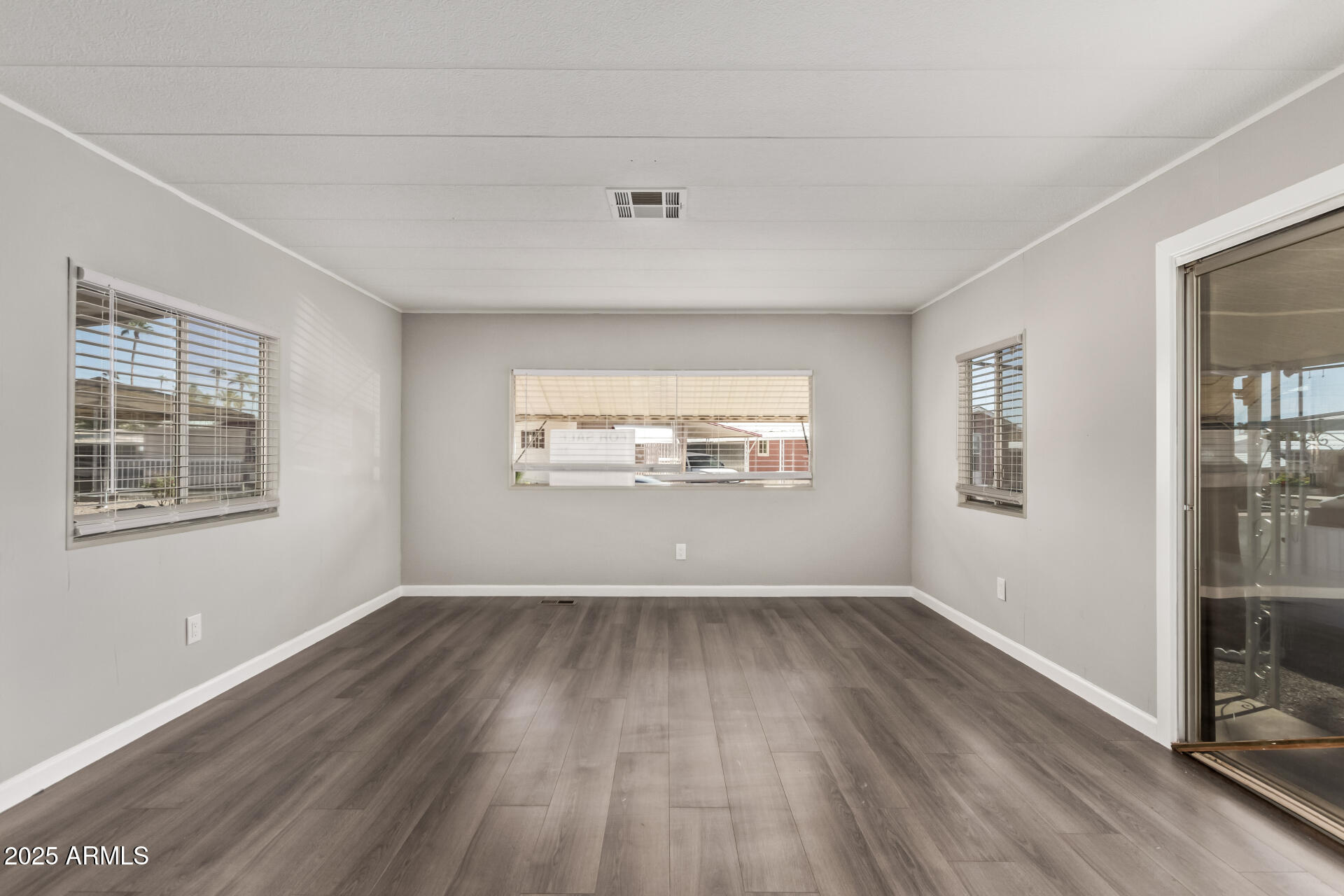 303 South Recker Road, Unit 200 Mesa, AZ 85206 - Photo 9 of 29 an empty room with wooden floor and windows