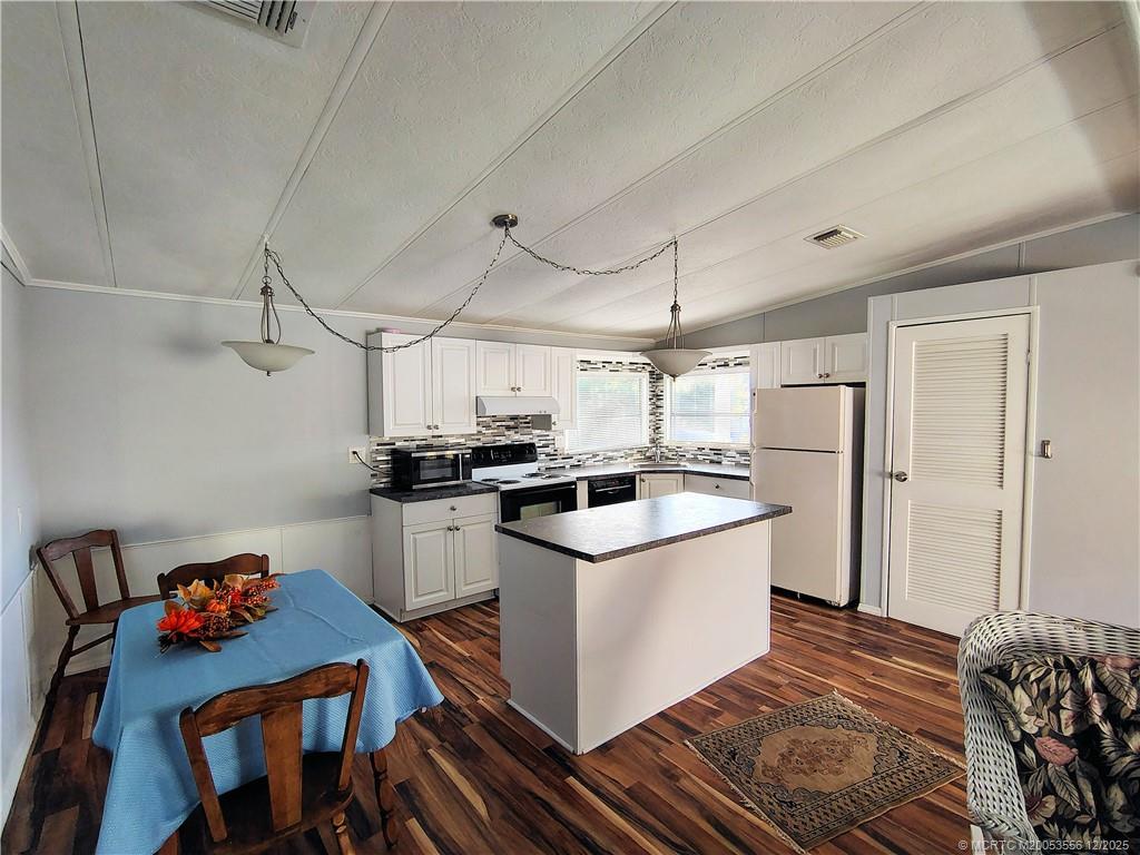 2581 Southwest Pontiac Place Stuart, FL 34997 - Photo 13 of 62 a kitchen with a sink a stove and refrigerator