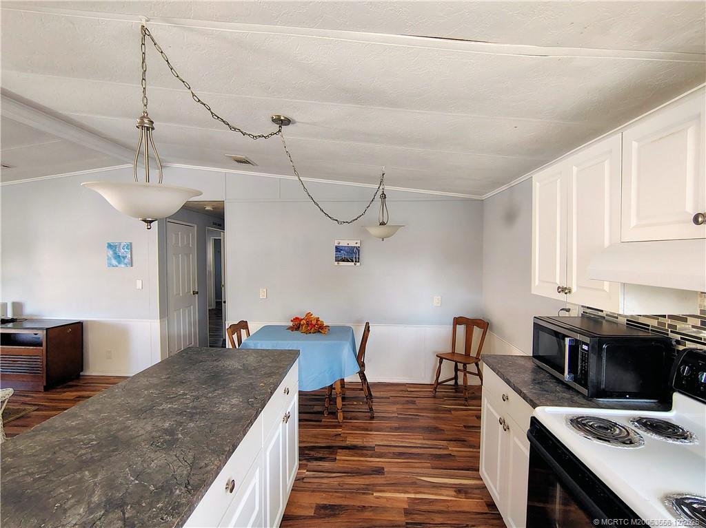 2581 Southwest Pontiac Place Stuart, FL 34997 - Photo 16 of 62 a kitchen with stainless steel appliances granite countertop a stove and a wooden floors