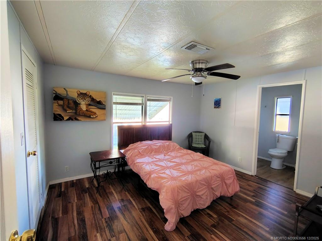 2581 Southwest Pontiac Place Stuart, FL 34997 - Photo 19 of 62 a bedroom with a bed and wooden floor