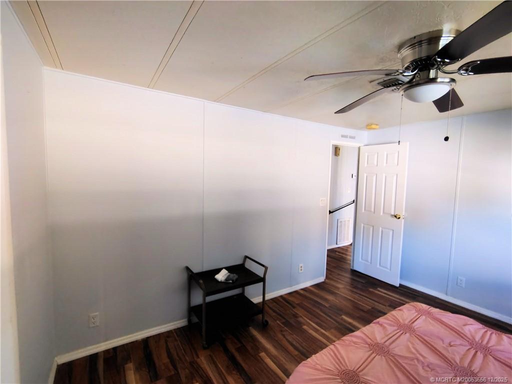 2581 Southwest Pontiac Place Stuart, FL 34997 - Photo 23 of 62 a bedroom with a bed and wooden floor