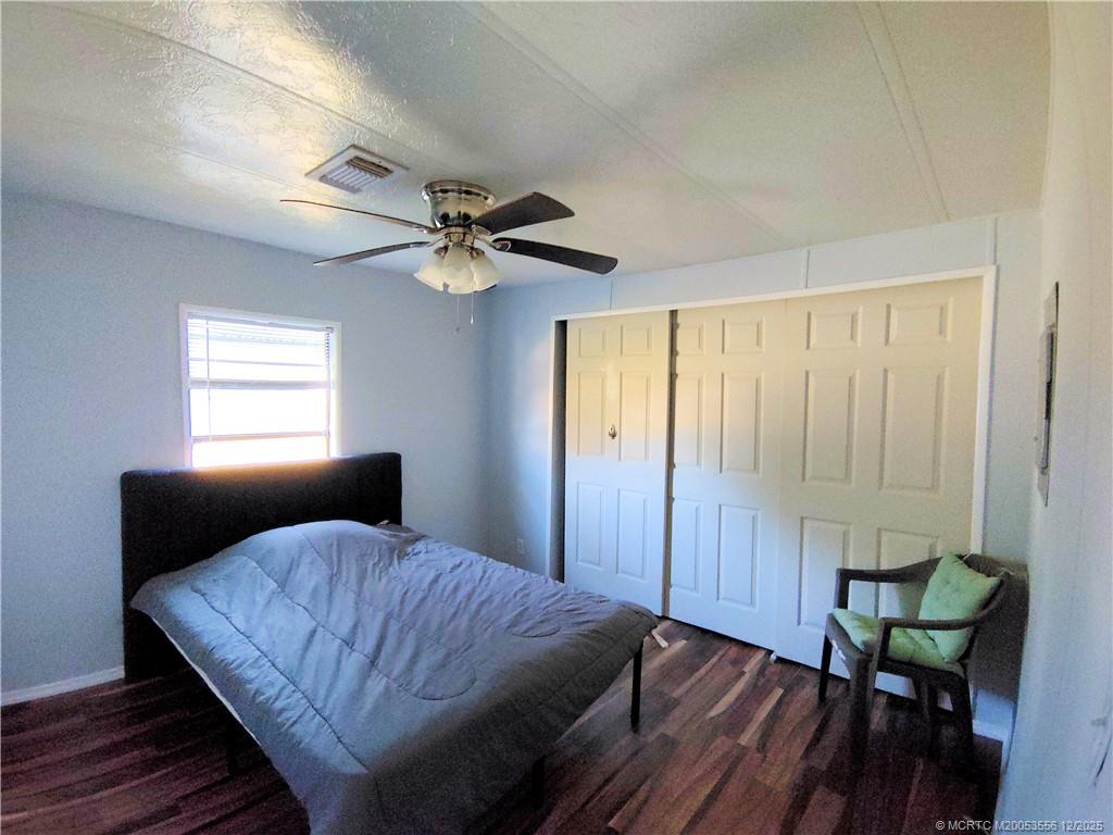 2581 Southwest Pontiac Place Stuart, FL 34997 - Photo 32 of 62 a bedroom with a bed and a chandelier