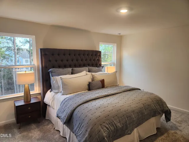 a bed sitting in a bedroom next to a window