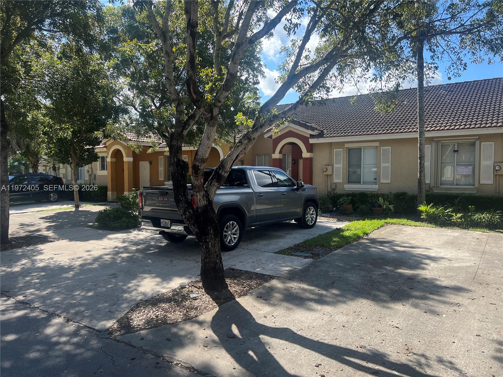 136 Southwest 15th Terrace Homestead, FL 33030 - Photo 2 of 37 a front view of a house with a yard and garage