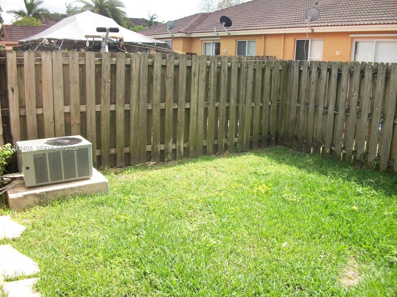 136 Southwest 15th Terrace Homestead, FL 33030 - Photo 4 of 37 a view of a backyard with potted plants and wooden fence