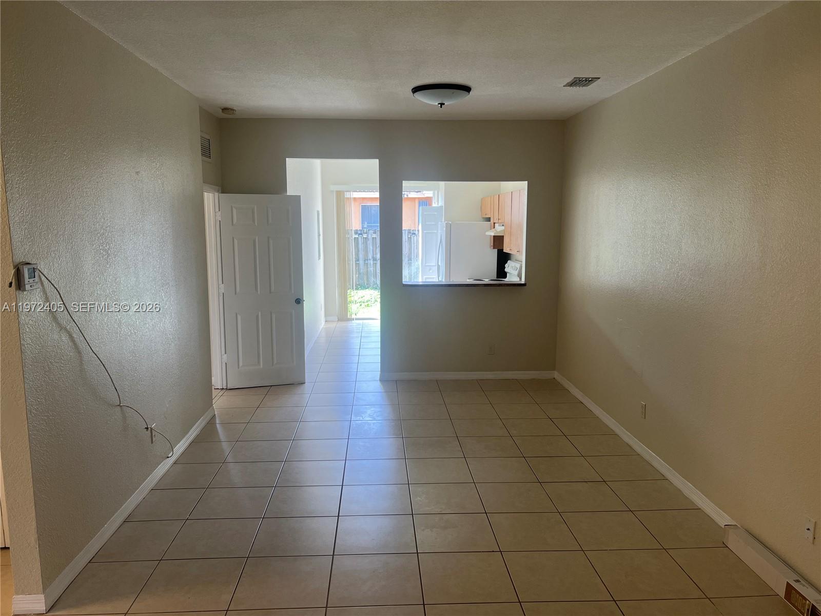 136 Southwest 15th Terrace Homestead, FL 33030 - Photo 7 of 37 en empty room with wooden floor and cabinet