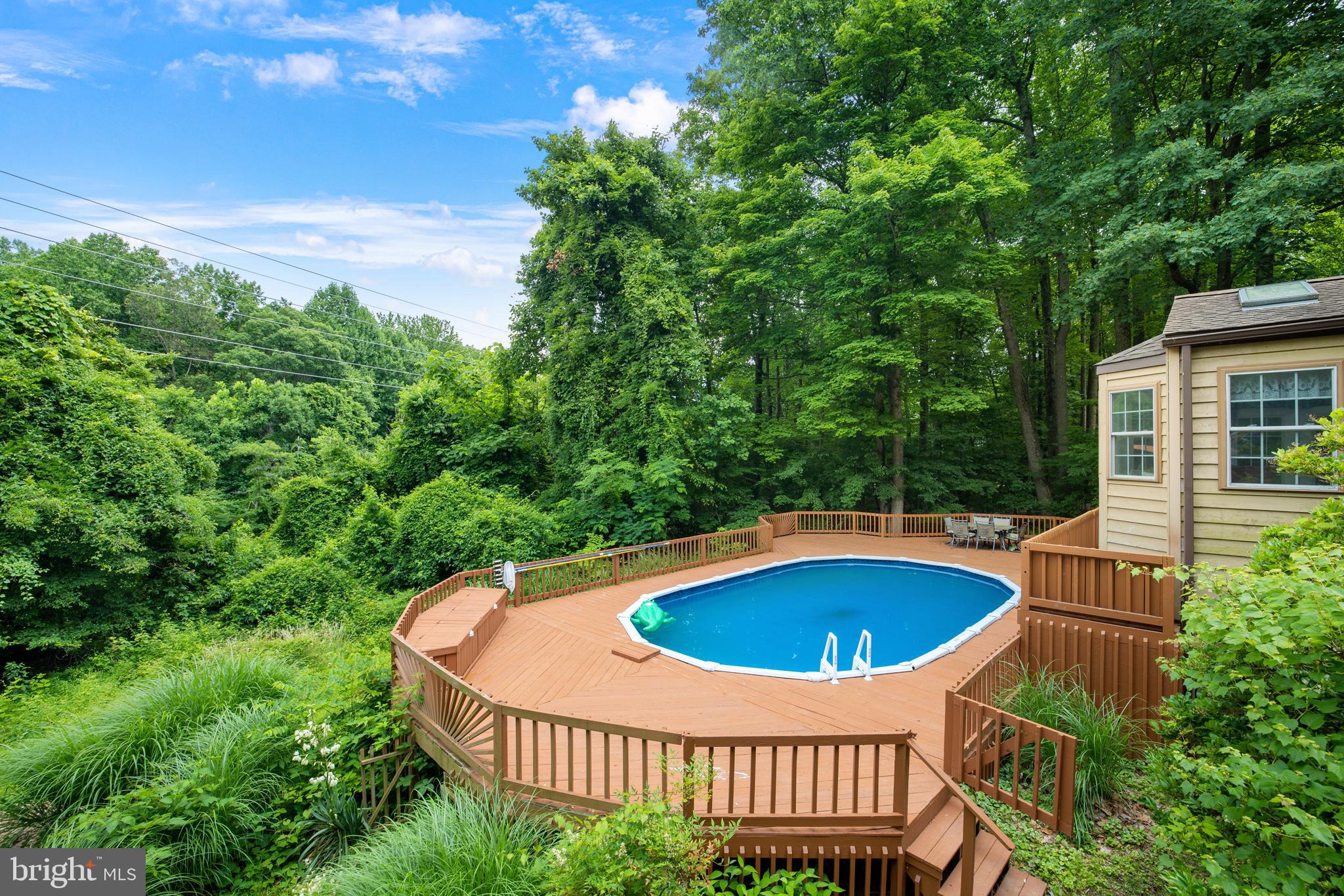 a view of a swimming pool and deck in the backyard