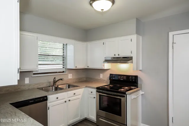 a kitchen with appliances a sink and cabinets