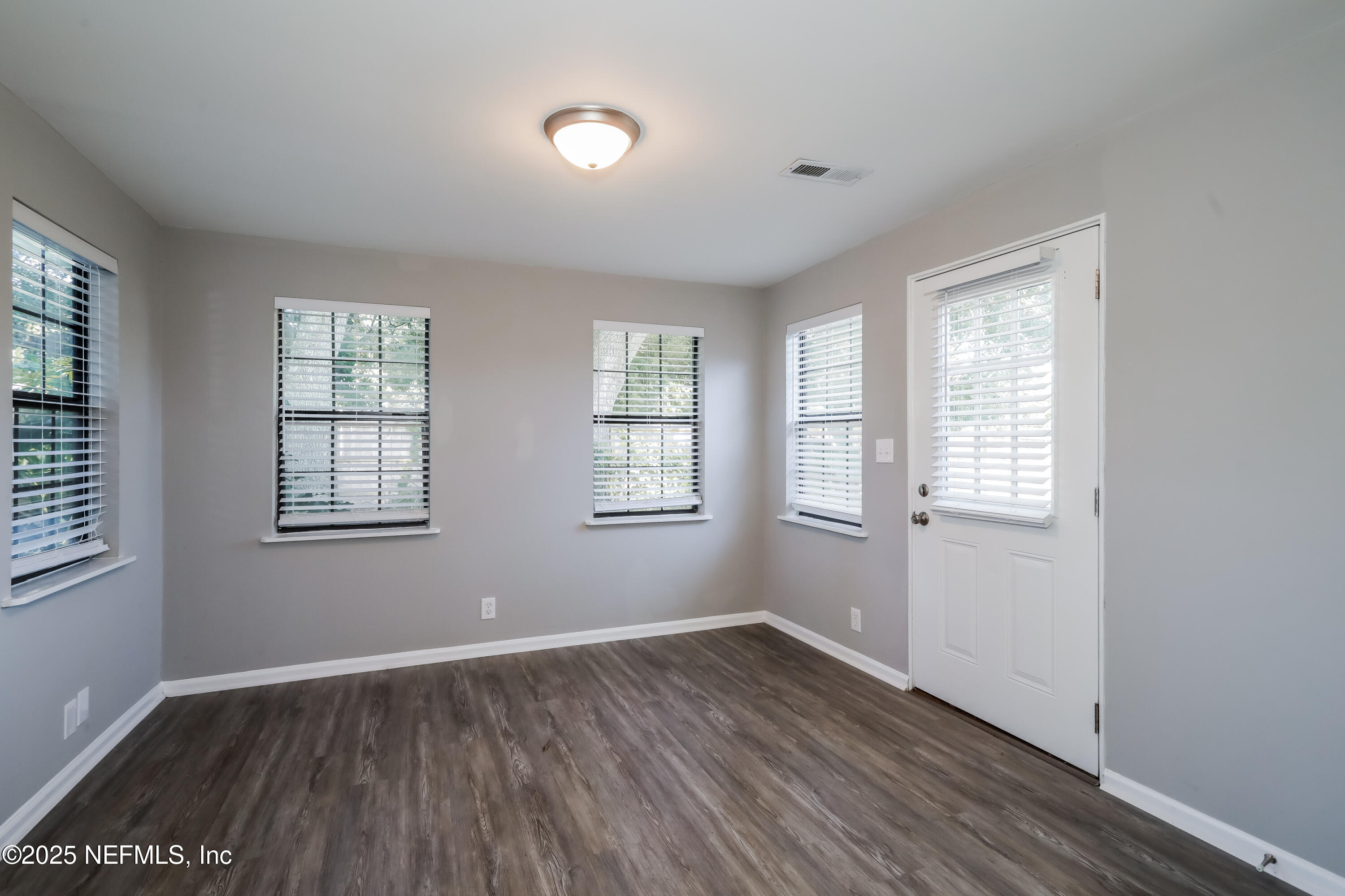 8408 Rampart Road Jacksonville, FL 32244 - Photo 8 of 15 an empty room with wooden floor and windows