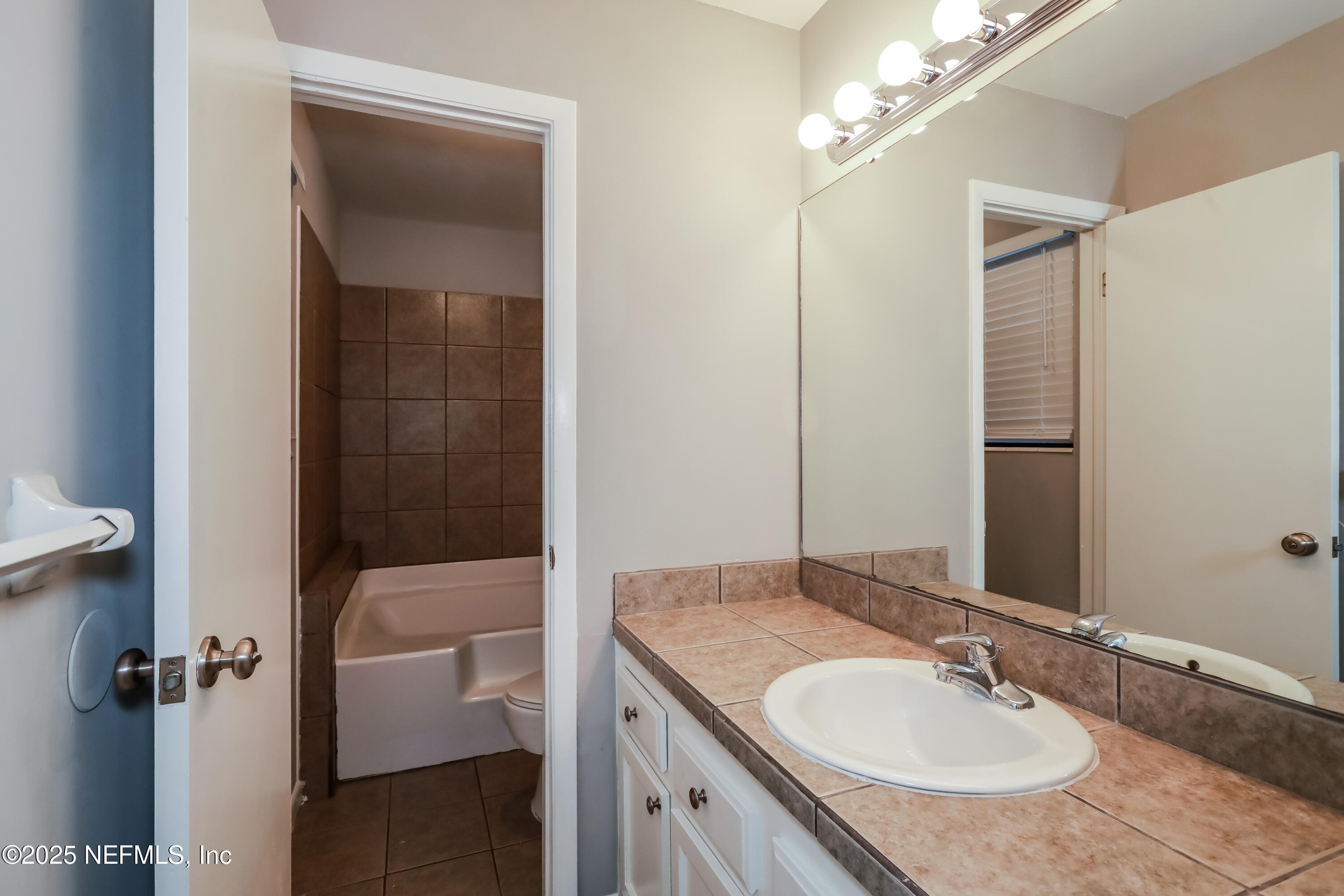 8408 Rampart Road Jacksonville, FL 32244 - Photo 10 of 15 a bathroom with a granite countertop sink a toilet and shower