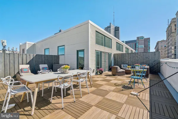 a view of a dinning table and chairs on the roof deck