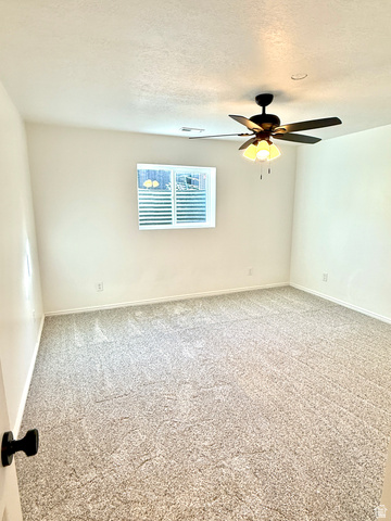 10158 High Point Lane Sandy, UT 84092 - Photo 20 of 24 Neutral-toned wall-to-wall carpeting, white painted walls, and a ceiling-mounted fan light fixture