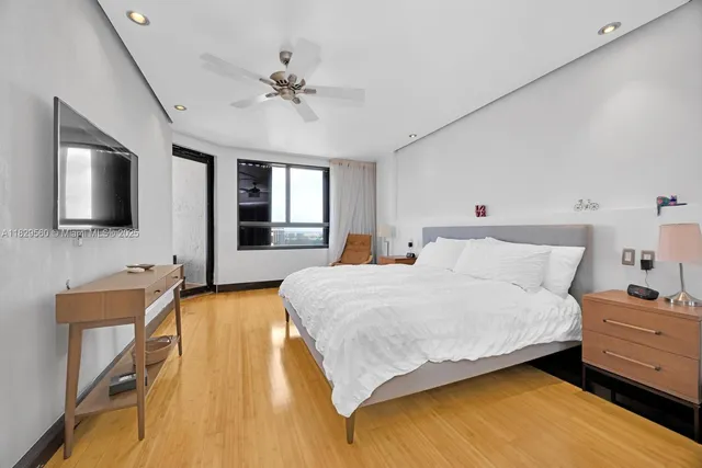 a spacious bedroom with a bed and a flat screen tv