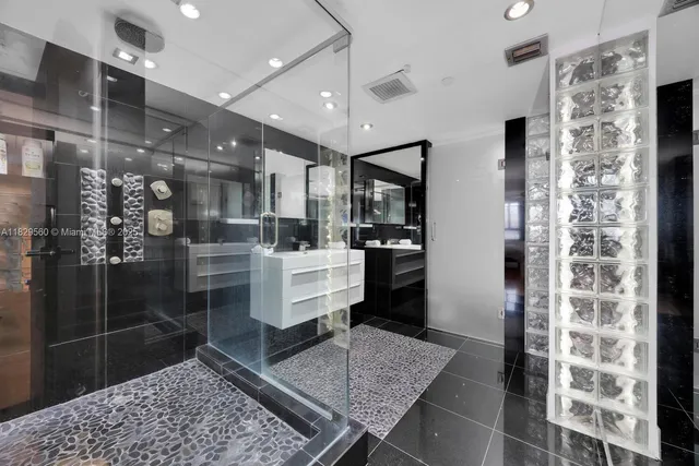 a room with lots of wooden furniture and a glass door shower