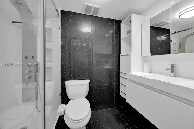 a bathroom with a toilet a sink and glass door