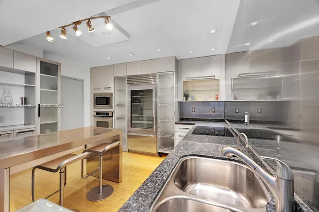 a kitchen with a sink a counter and chairs