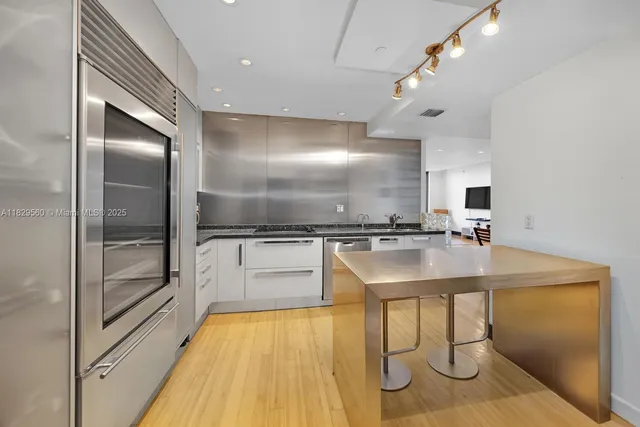 a kitchen with kitchen island a sink appliances and a counter top space
