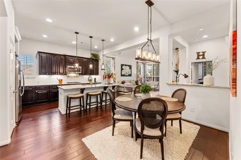 a view of a dining room and livingroom with furniture wooden floor a chandelier