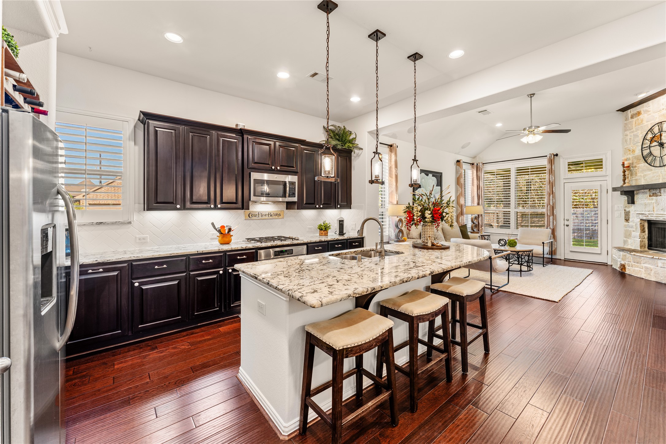 6014 Barrett Cove Court Richmond, TX 77407 - Photo 16 of 45 a kitchen with stainless steel appliances granite countertop a stove top oven a sink dishwasher a dining table and chairs with wooden floor
