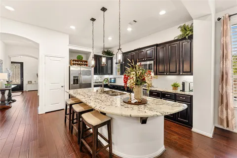 a kitchen with a table chairs refrigerator and microwave