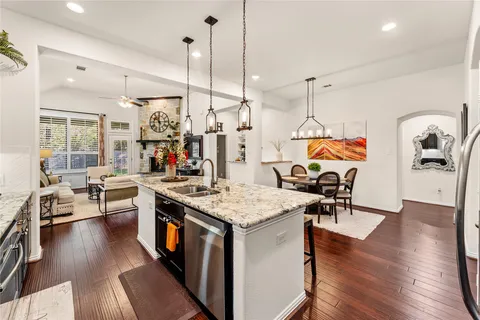 a open kitchen with stainless steel appliances granite countertop a stove and refrigerator