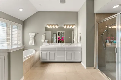 a spacious bathroom with a granite countertop sink mirror and a bathtub