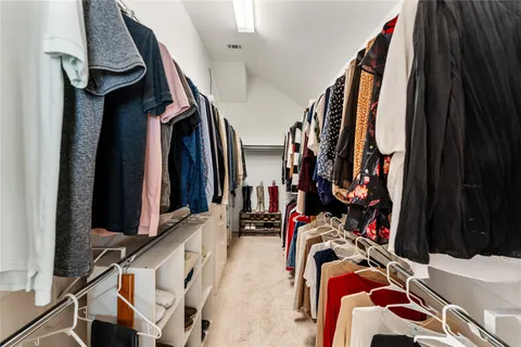 a view of walk in closet with clothes and shoes