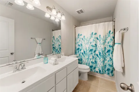 a bathroom with a sink a toilet and a large mirror