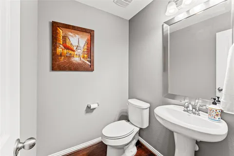 a bathroom with a toilet a sink and mirror