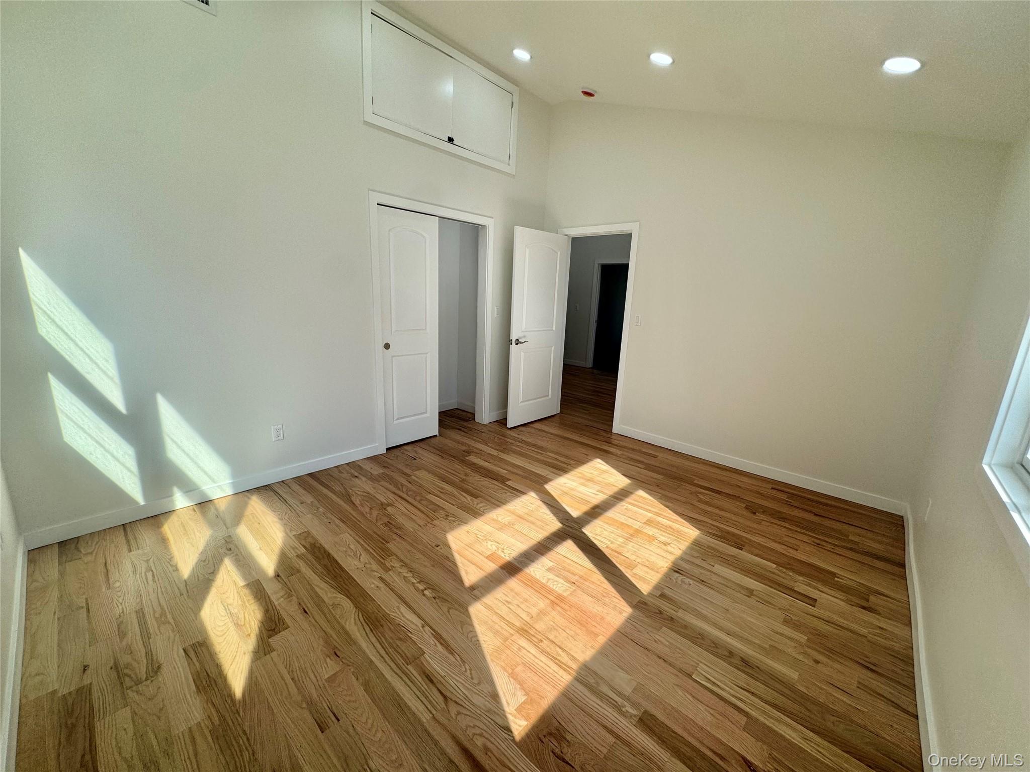 98 Steamboat Road Great Neck, NY 11024 - Photo 23 of 23 Bright, open room featuring hardwood flooring throughout, recessed ceiling lighting, and multiple windows allowing abundant natural light
