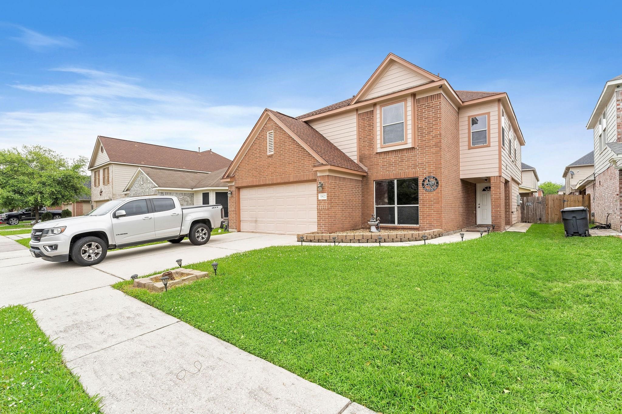 a front view of a house with a garden and parking space