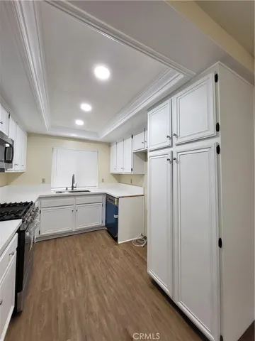 a large kitchen with a lot of counter space and wooden floor