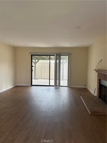 an empty room with wooden floor and fireplace