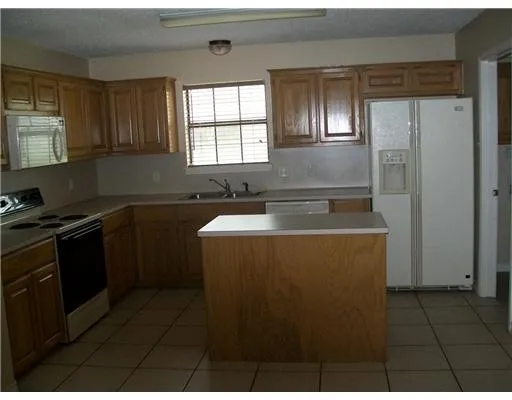 a kitchen with a sink a stove a refrigerator and cabinets