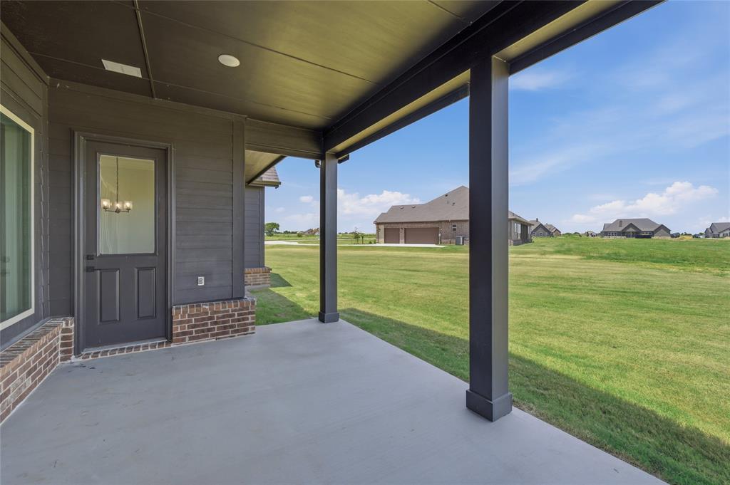 2305 Gypsum Street Krum, TX 76249 - Photo 22 of 26 Covered concrete patio featuring dark horizontal siding and a partial brick facade
