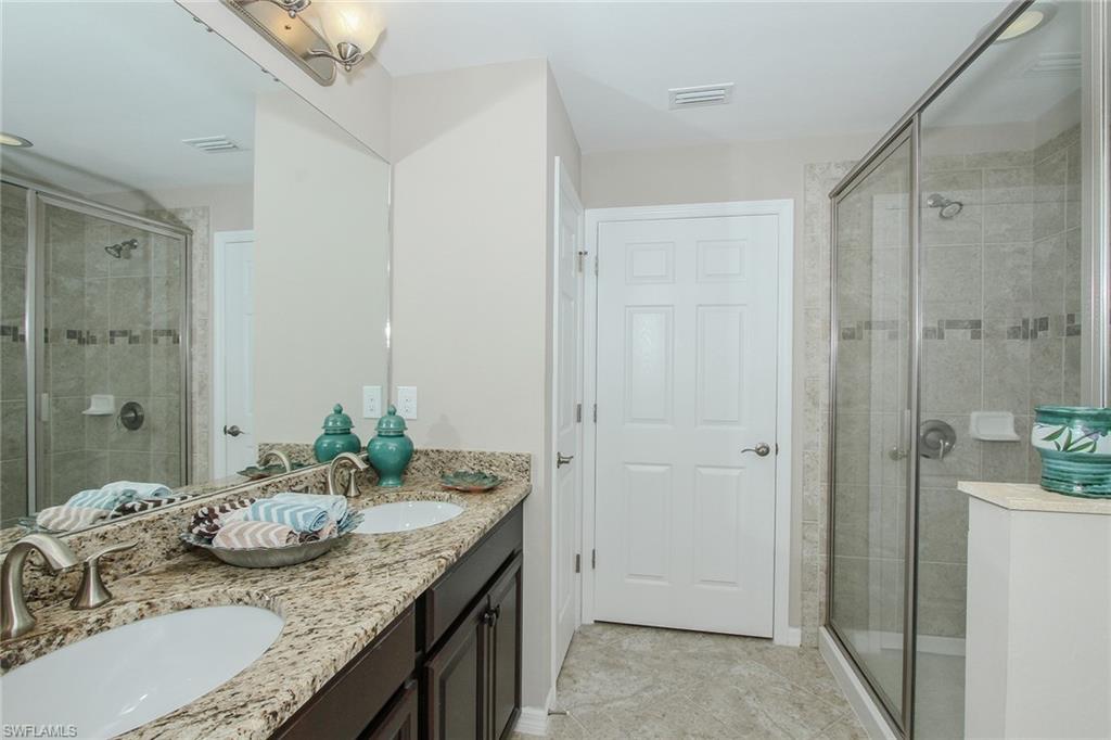 8531 Violeta Street, Unit 101 Estero, FL 34135 - Photo 11 of 23 a bathroom with a granite countertop sink a mirror and a shower