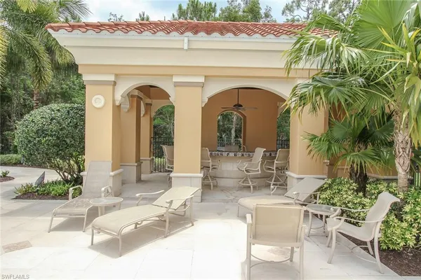 a view of white house with outdoor seating and plants