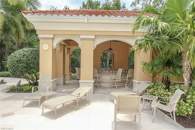 a view of white house with outdoor seating and plants