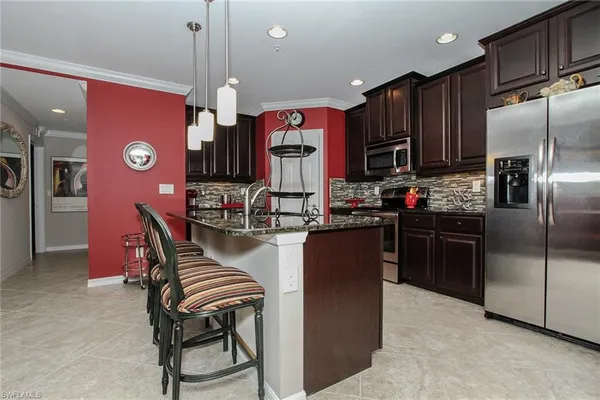 a kitchen with stainless steel appliances granite countertop a stove refrigerator and a sink